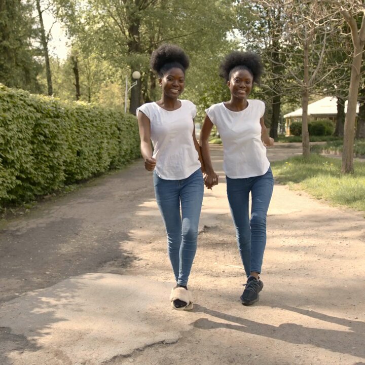 Community members walking on a tree-lined path in Ghana